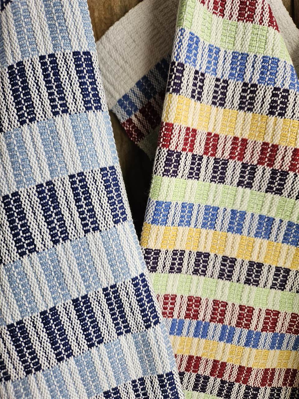 Detailaufnahme von blau-weissen und mehrfarbigen handgewebten Tüchern