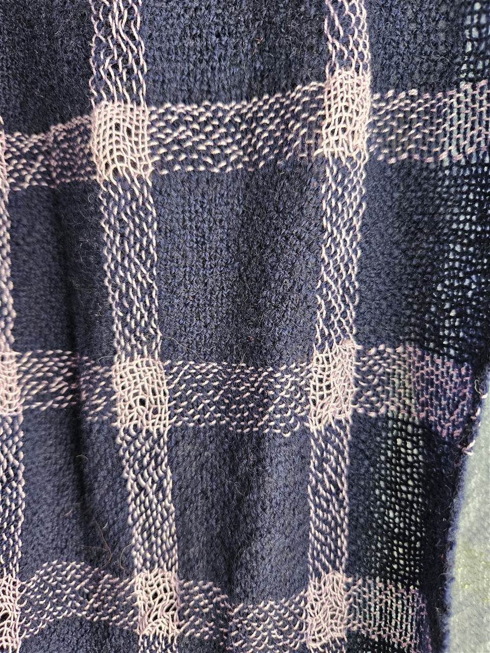 Detailaufnahme eines dunkelblauen Schals mit hellem Karomuster