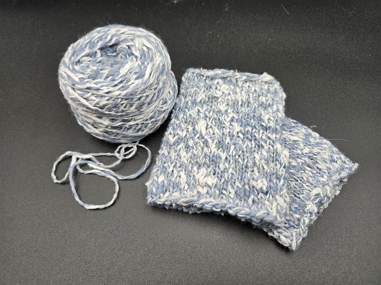 Blau-weisses Garn aus Schweizer Seide und Alpaka mit einer Strickprobe