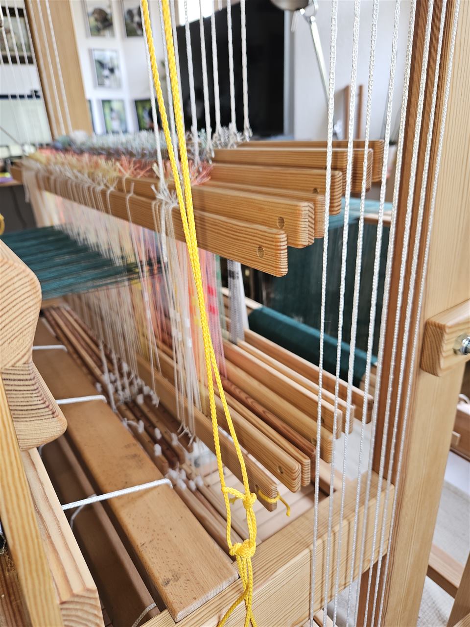 Detail der Holzschäfte und Fäden am Webstuhl